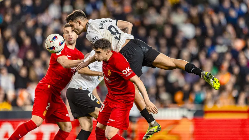 Cầu thủ của Valencia đi bóng vượt qua hậu vệ Mallorca trên sân cỏ Cầu thủ của Valencia đi bóng vượt qua hậu vệ Mallorca trên sân cỏ